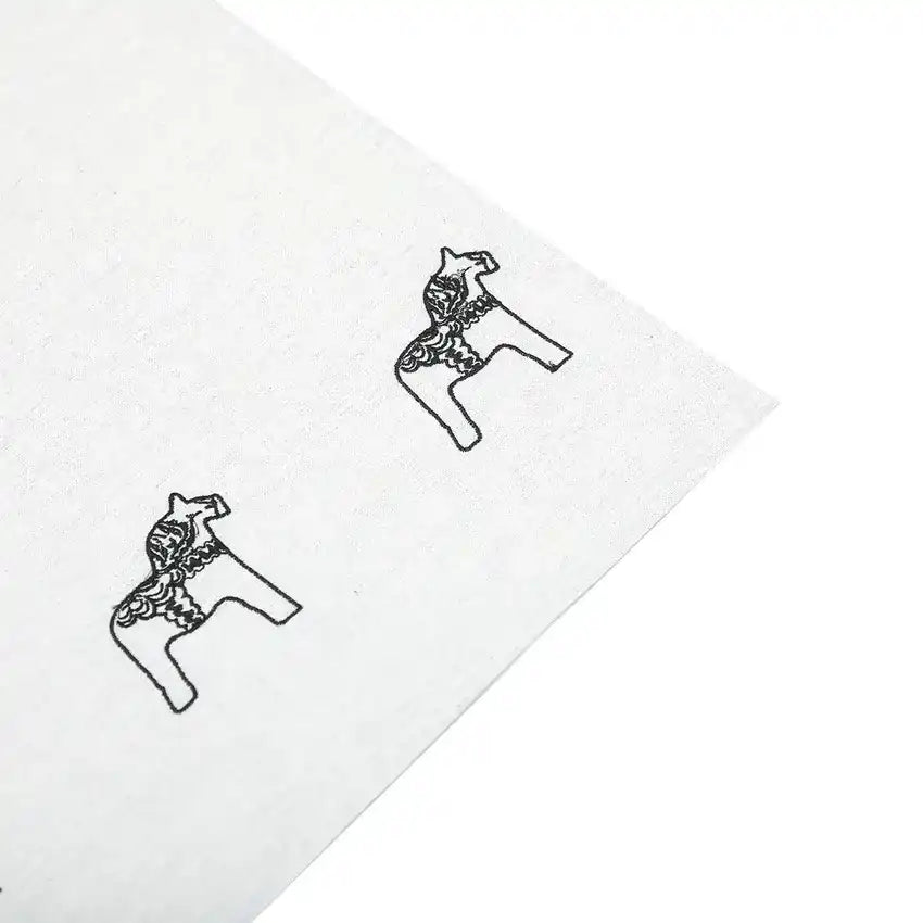 Ett vitt tyg med två broderade svarta Dalahästar.