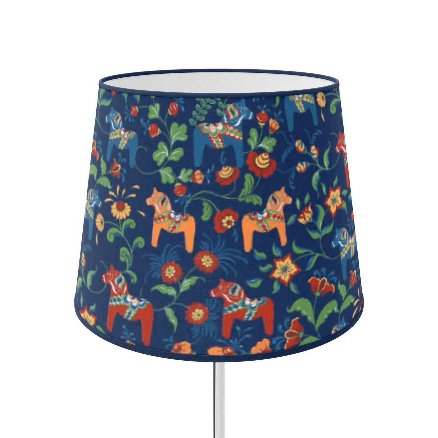 En mörkblå lampskärm prydd med ett livfullt mönster av traditionella svenska dalahästar i orange, rött och grönt bland blomsterornament.